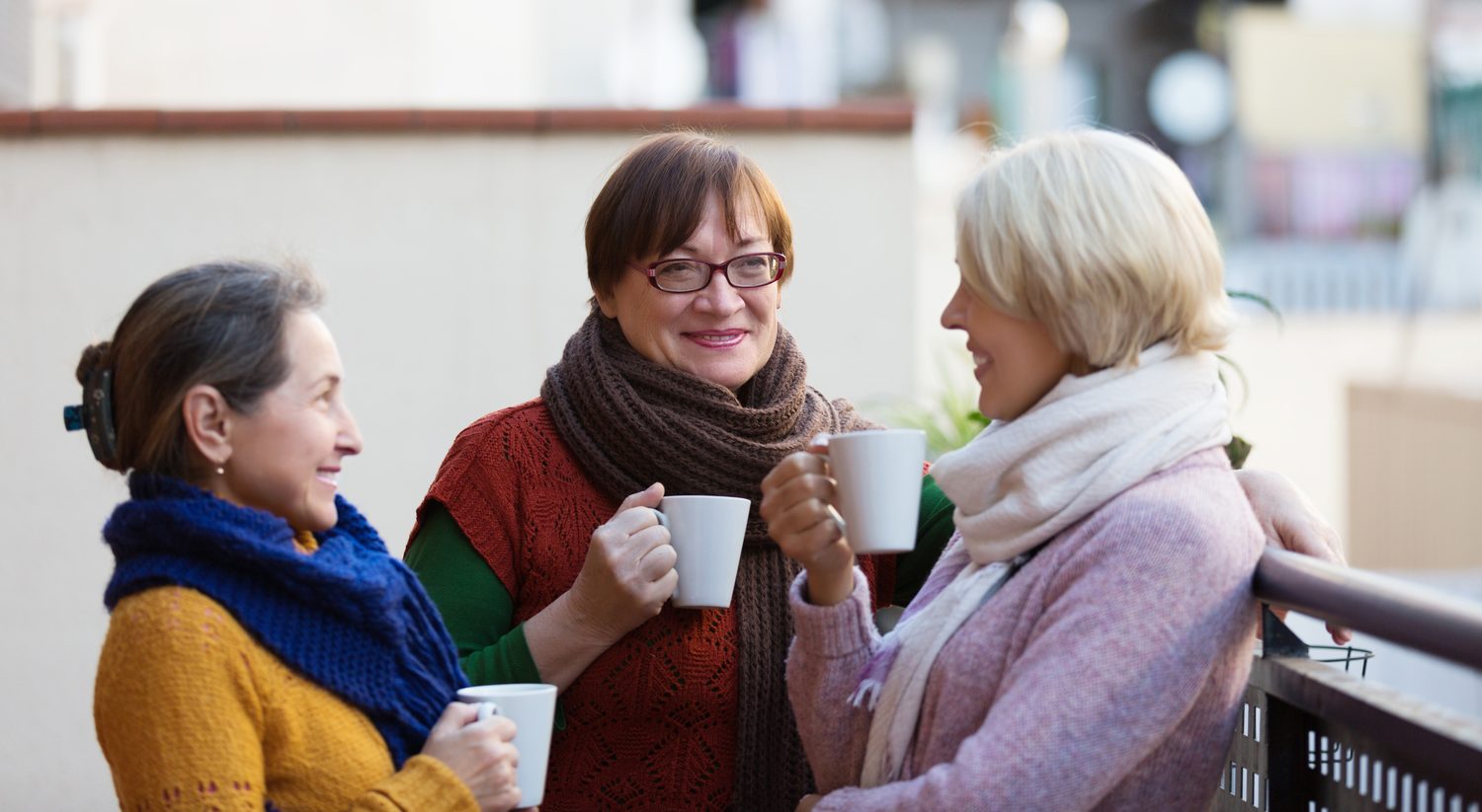 Drei ältere Frauen unterhalten sich bei einer Tasse Kaffee